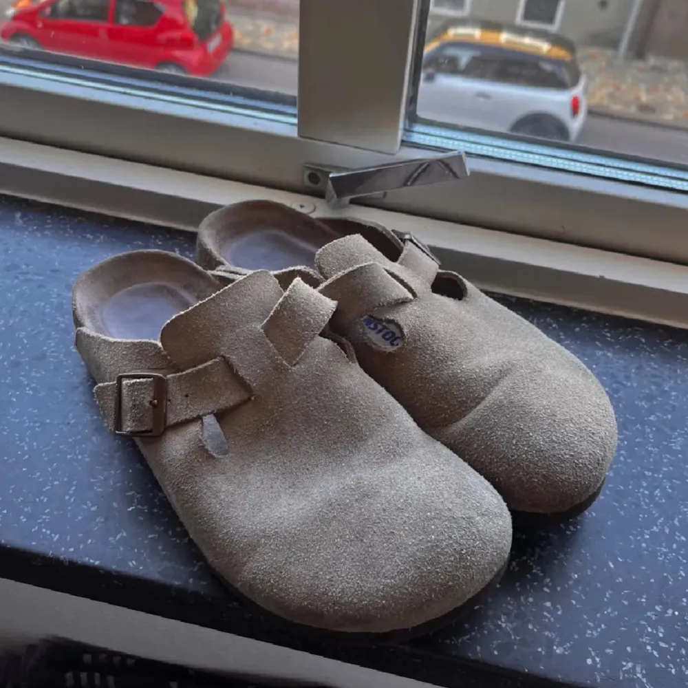 Säljer ett par bekväma och stilrena Birkenstock Boston i beige mocka. De har en justerbar rem med spänne för perfekt passform. Perfekta för en avslappnad stil och passar bra till både vår och sommar.. Skor.