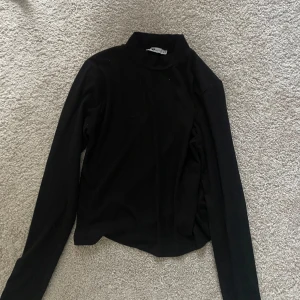 Långarmad tröja - En svart tajt långarmad tröja men krage🤍