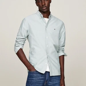 Ljusblå skjorta från Tommy Hilfiger - Säljer en stilren ljusblå skjorta från Tommy Hilfiger i storlek S. Skjortan är långärmad och har en klassisk krage med knappar. Nypris 1099kr! 10/10 skick då jag bara använt den fåtal gånger!