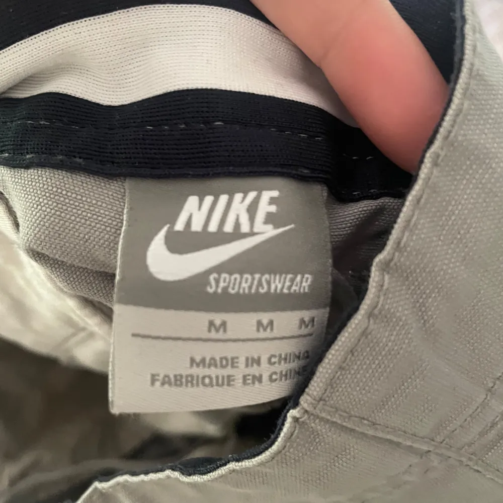 Ett par beige/grå cargo pants från Nike. Baggy fit med snören så man kan dra åt vid fötterna. Köpt secondhand, men endast använda få gånger.   Skriv för fler bilder eller mått!!. Jeans & Byxor.