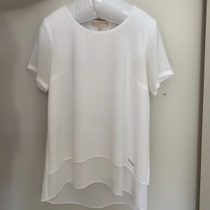 Michael kors blus  - Vit blus med volanger, den är som ny. Endast använd en gång!
