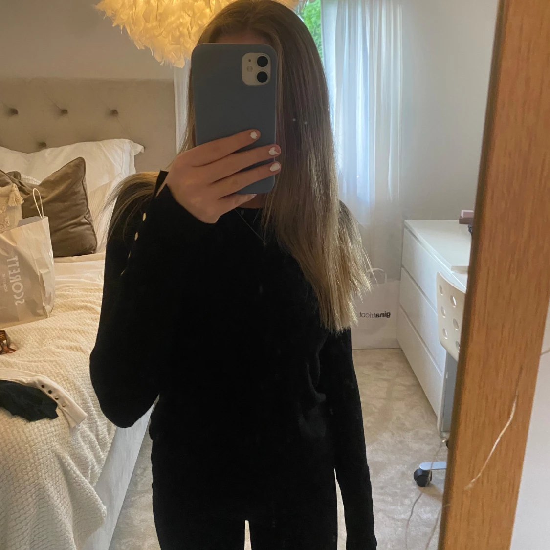 Svart tröja med detaljer på ärmarna