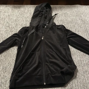 Svart hoodie med dragkedja - Säljer en svart hoodie med dragkedja. Den har en skön och avslappnad passform med långa ärmar och en praktisk huva. Perfekt för kyliga dagar eller som ett extra lager. Den är i bra skick och redo för nya äventyr!