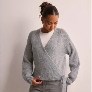 Stickad tröja - Grå stickad tröja från Only köpt från Nelly som man knyter på sidan. Helt ny med lappen kvar. Storlek XS men mer som en S. Köpt för 459kr. Mitt pris 399kr💕