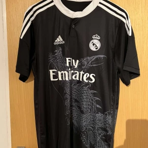 Retro Real Madrid tredjeställ säsong 14/15 - Liten i storlek, perfekt för dig som inte vill ha en hängig fotbollströja.(passar även M)