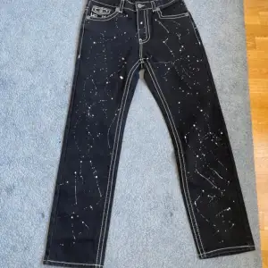 Black True Religion jeans with white paint splatter design