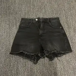 Säljer ett par svarta jeansshorts från H&M Divided. De är högmidjade med en cool fransig kant längst ner. Perfekta för en avslappnad sommarlook! 