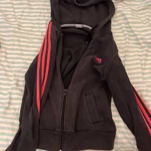 Rosa och svart adidas kofta  - Säljer en rosa och mörk grå/svart adidas kofta! Har använt den cirka 1 gång och är i jätte bra skick 😁