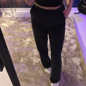 Kostymbyxor  - Svarta kostymbyxor med små vita ränder. Högmidjade, storlek 34. Knappt använda väldigt bra skick 