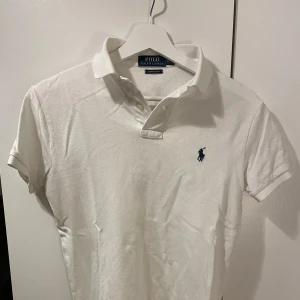 Polo ralph lauren piké  - Säljer min polo piké eftersom den blivit förliten. Den är i väldigt bra skick färgen är vit med mörkblå logga storlek XS 