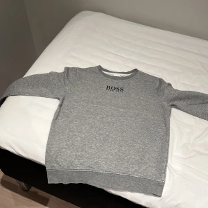 Hugo boss tröja  - Skick 7/10 börjar bli lite sliten av tvätten vid slutet av armarna. Texten är kvar och är i sin plats den passar på 12 åringar