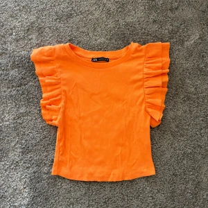 Volangtopp - Orange volangtopp från zara i storlek S. Använd vid enstaka tillfälle! Toppen skick!