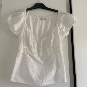 Vit topp - Säljer en jättefin vit topp från Nelly som aldrig är använd 