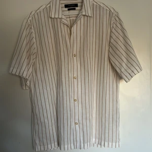 Kortärmad linneskjorta - Vit-ljusbrun randig linneskjorta från Jack & Jones i mycket. Skick 8/10