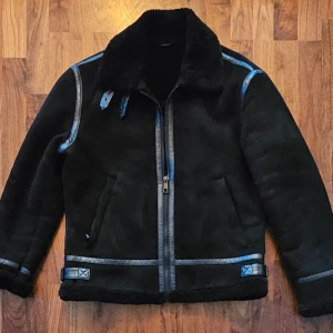 Svart jacka från Zara - Säljer en snygg svart jacka från Zara i mycket bra skick. Den har en cool design med svarta läderdetaljer och en mysig insida. Perfekt för höst och vinter! Jackan har dragkedja och spännen vid kragen för extra stilpoäng.