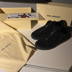  Axel Arigato clean 90 zip - Säljer ett par stilrena svarta sneakers från Axel Arigato i mocka. Modell: Clean 90 zip, använt skick. 7/10. Renas innan frakt
