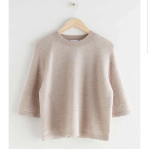 Beige stickad tröja - Mysig beige stickad tröja med trekvartsärm. Perfekt för höst och vår, med en enkel och stilren design. Passar bra till både jeans och kjol för en avslappnad look.