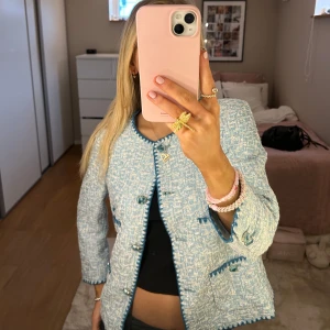 Blå och vit tweedjacka - Säljer en superfin blå och vit tweedjacka med snygga knappar och detaljer. Den har en klassisk stil med en modern twist, perfekt för både vardag och fest. Jackan har långa ärmar och en normal passform. Den är i mycket bra skick och redo för en ny ägare!
