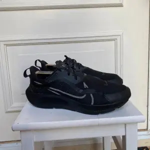 Säljer ett par svarta Nike sneakers i mycket bra skick. De har en stilren design med snörning och är perfekta för träning eller vardagsbruk. Skorna är i storlek herr 45 och har en bekväm passform.