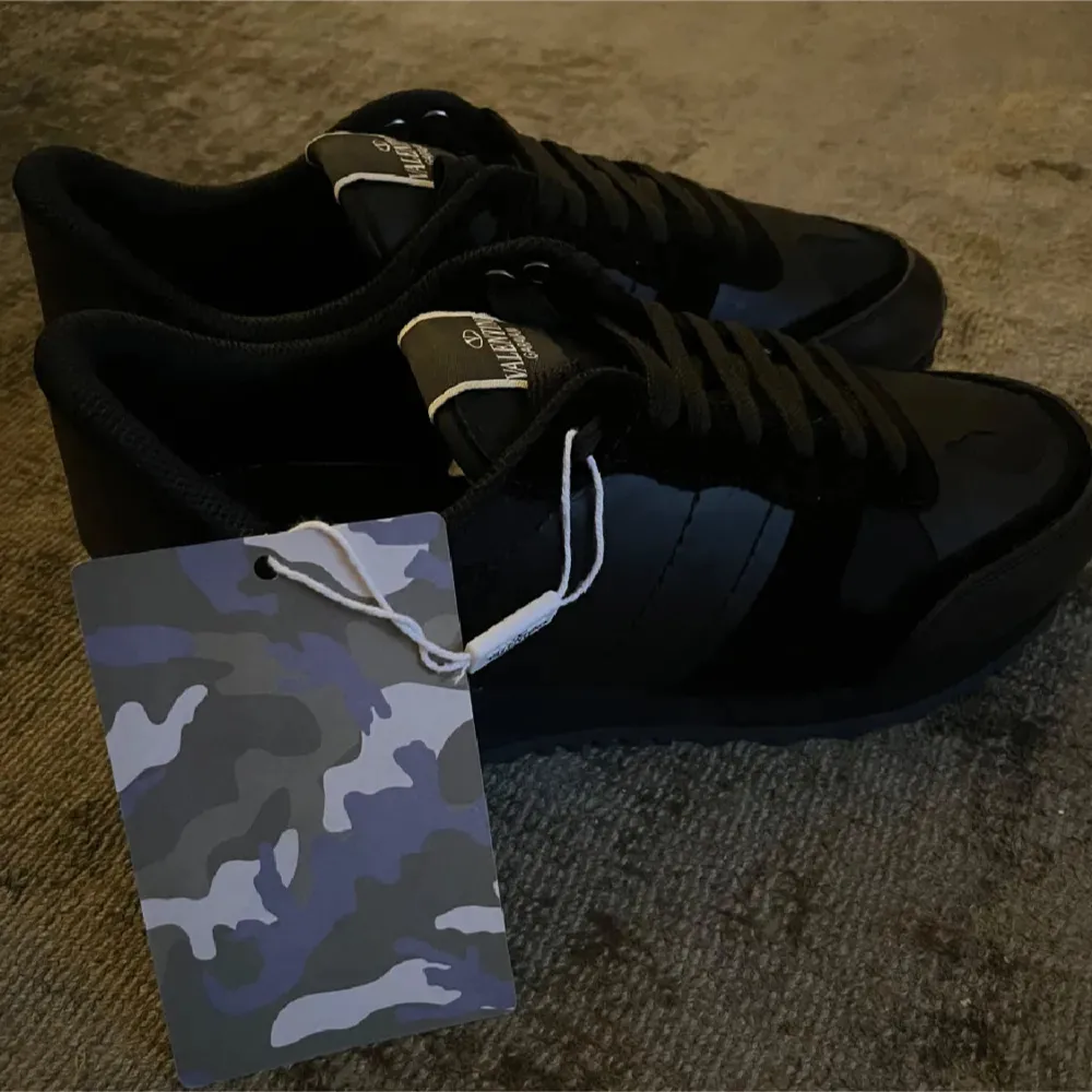 Snygga svarta sneakers från Valentino Garavani i camouflagemönster. Skorna är i nytt skick och kommer med originaltaggar. Storlek 41 men passar även mig med 42.Har tyvvär ingen box till de.Skriv vid funderingar.. Skor.