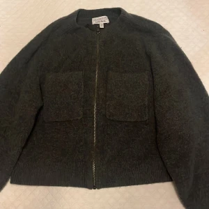 Kofta med dragkedja från other stories!🩷 - Super söt stickad kofta med dragkedja från other stories! Den är ser mörkgrå ut i kameran men den är egentligen en as fin mörkgrön som passar perfekt nu till vintern. Upplever den som ganska kort på mig som är 175 cm💕Köpt förra året och ganska använd men finns inget tecken på användning😊