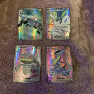Pokémonkort med holografisk design - Säljer fyra Pokémonkort med holografisk design. Korten inkluderar Magnezone ex, Gardevoir ex, Banette ex och Miraidon ex. Perfekt för samlare eller Pokémon-entusiaster som vill utöka sin samling med unika och glänsande kort.