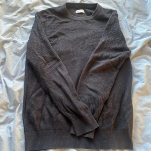 Mörkblå tröja från These Glory Days - Säljer en stilren mörkblå tröja från These Glory Days i storlek medium. Tröjan har en diskret textur och långa ärmar, perfekt för en avslappnad look. Passar bra till både jeans och chinos.