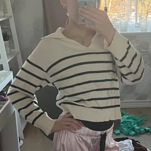 Randig tröja  - Säljer en stilren randig tröja i cream vitt och svart med en unik krage bak och en liten V ringning fram. Tröjan har långa ärmar och ribbade muddar vid ärmslut och nederkant. Perfekt för en stilren look. Använd runt 3 gånger. Kostade 300 kr när jag köpte den. Älskar den! Så himla fin och jätte jätte skön!! 😍😍