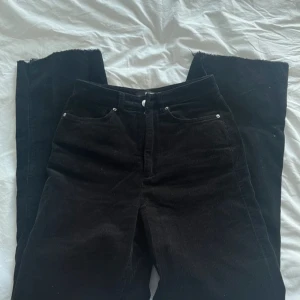 Svarta byxor bikbok - Snygga svarta manchesterbyxor med klassisk design. Byxorna har en rak passform. De har fickor både fram och bak samt hällor för bälte (en är sönder, sista bilden).