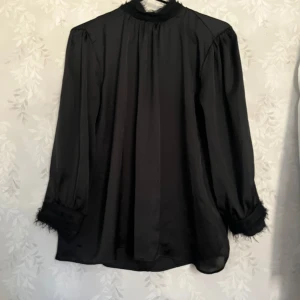 Svart Zara siden blus - Säljer nu denna svarta siden blus ifrån Zara, säljer denna för jag rensar ut garderoben och har inte andvänt den på ett tag. Den har detaljer vid ärmarna och halsen som är sjukt snygga, skulle även säga att den är sann i storleken (S) och funkar både till vardags som till finare tillfällen❤️ skriv för mer frågor eller funderingar🥰