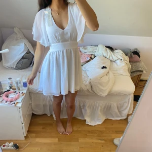 Vit klänning  - Säljer en söt vit klänning med v-ringning och korta ärmar. Klänningen har en knytning i ryggen och är perfekt till student eller sommaren. Köpt förra sommaren, aldrig använd och har alla lappar kvar.