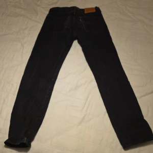 Svarta Levi's 501 jeans - Säljer ett par klassiska svarta Levi's 501 jeans. De har en knappgylf och fem fickor med nitar. Perfekta för en stilren look.