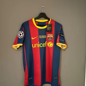 FC Barcelona fotbollströja med Messi 10 - Säljer en klassisk FC Barcelona tröja från Nike med Messi 10 på ryggen. Den är helt ny och har tagg! Den är i storlek M och är en replika. Den har Champions League patch och respect. Kom gärna med prisförslag!