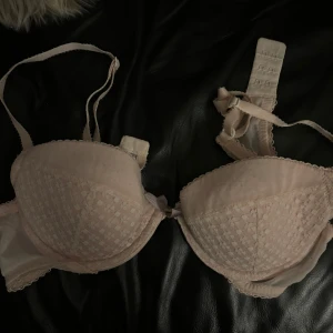 Beige bh - Säljer en elegant beige bh med spetsdetaljer och justerbara axelband. Den har en klassisk design med hakknäppning bak och vadderade kupor för extra komfort.💗
