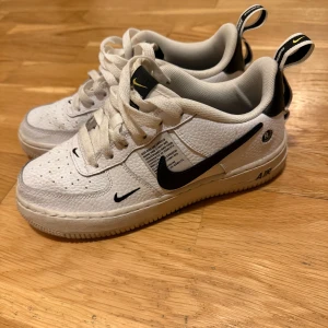 Vita Nike Air Force sneakers - Snygga vita Nike Air Force sneakers med svarta detaljer och klassisk snörning. 