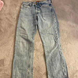 Ljusblå jeans från Jack & Jones - Säljer ett par ljusblå jeans från Jack & Jones med relaxed/Chris fit. De har en klassisk femficksdesign och knappgylf. Perfekta för en avslappnad stil.
