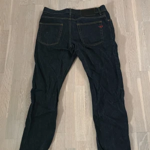Svarta jeansbyxor - Snygga svarta jeansbyxor med klassisk femficksdesign och knappgylf. Perfekta för en stilren look. Passar till det mesta och är ett måste i garderoben.