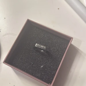 Silverfärgad ring MOM - En stilren silverfärgad ring med texten 'MOM' ingraverad. Perfekt som en personlig present eller för att bära själv. Säljer den för använder bara guld. Köptes för 399kr. Pris kan diskuteras.