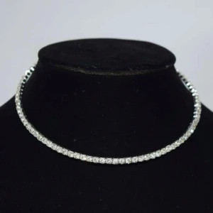 Glittrigt silverhalsband - Elegant och glittrigt halsband i silver med en rad av gnistrande stenar. Perfekt för att lägga till en touch av glamour till din outfit.