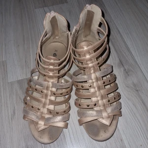 Beige sandaler från Din Sko - Snygga beige sandaler från Din Sko med flera remmar och dragkedja baktill. Perfekta för sommarens alla äventyr. De har en öppen tå och dekorativa nitar på remmarna.