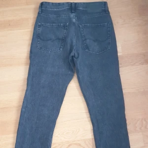 Svarta jeans från Jack & Jones - Snygga svarta jeans från Jack & Jones med en klassisk femficksdesign. De har en dragkedja och knapp framtill. Perfekta för en avslappnad stil.