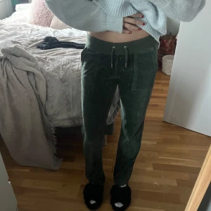 Juicy mjukis byxor - Säljer ett par gröna mjukisbyxor i sammet från Juicy Couture. De har en loose passform och är perfekta för mysiga dagar hemma. Byxorna har snörning i midjan och fickor både fram och bak. Superbekväma och stiliga för en avslappnad look! Storleken är xxs men passar upp till en S. Nypris är 1000kr.