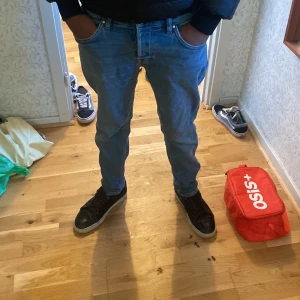 Blå jeans från Karve - Säljer ett par snygga blå jeans från Karve. De har en klassisk femficksdesign och är i bra skick. Perfekta för både vardag och fest! Passformen är slim och de är midwaist, vilket gör dem bekväma och stiliga. Perfekta för höst och vår. En defekt att det är hål i högra fickan