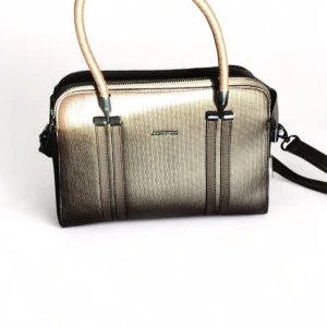 Just&Polo väska - Snygg axelväska i metallisk färg med dragkedja och flera fack. Perfekt för både vardag och fest. Den har en justerbar axelrem och bekväma handtag. Väskan är i mycket bra skick och har en stilren design.