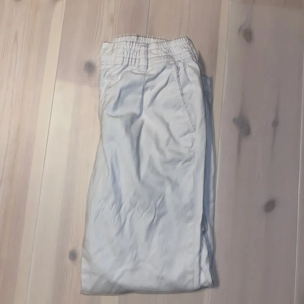 Säljer ett par vita byxor från Jack & Jones i bra skick. De har en elastisk midja och en knapp framtill. Perfekta för en avslappnad stil och passar till både vardag och fest. Byxorna är bekväma och lätta att matcha med olika toppar.. Jeans & Byxor.