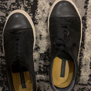 Svarta sneakers från Sneaky Steve - Säljer ett par svarta sneakers från Sneaky Steve i riktigt bra skick. De har en klassisk design med snörning och vit sula. Perfekta för vardagsbruk och passar till det mesta. Tillverkade i Portugal.