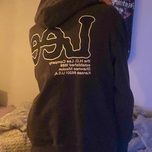 Brun hoodie från Lee - Säljer en brun hoodie från Lee i bra skick. Den har en stor logga på ryggen och en mindre på bröstet. Perfekt för höst och vinter med sin mysiga passform och långa ärmar. Passar både till vardags och chillkvällar. Hör av dig vid intresse!