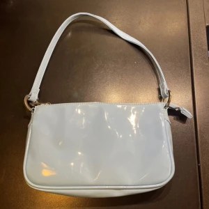 Ljusblå axelväska från Stradivarius - Säljer en superfin ljusblå axelväska från Ginatricot. Väskan har en stilren design med en praktisk dragkedja upptill. Perfekt för både vardag och fest! 💙