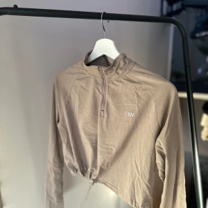 Träningströja ICANIWILL - Träningströja från ICANIWILL i mycket bra skick. Tröjan har en halv dragkedja och är croppad