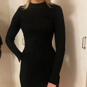 Svart ribbad klänning från Gina Tricot - Snygg svart ribbad klänning från Gina Tricot i storlek S. Den har en tight passform och långa ärmar, perfekt för höst och vinter. Klänningen är i mycket bra skick och passar både till vardags och festliga tillfällen.